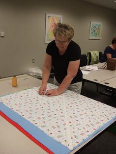 a woman is making a quilt in an office