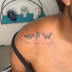 a woman with three butterflies on her shoulder and the words you are enough written in cursive ink