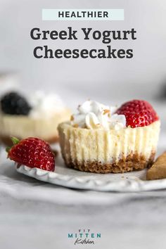 a small cheesecake on a plate with strawberries and cookie pieces around it that says healthier greek yogurt cheesecakes