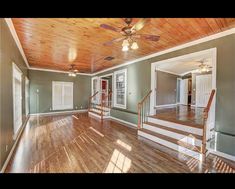 an empty living room with wood floors and ceiling fan