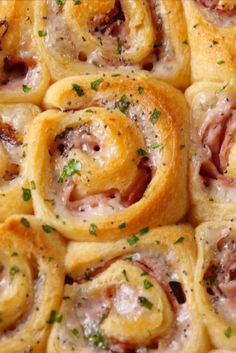 rolls with ham and cheese on them are arranged in the shape of spirals, topped with parsley