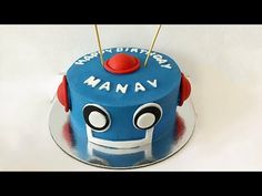 a blue birthday cake with red and white frosting on it's top, decorated with an image of a robot