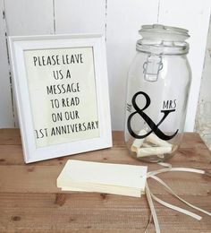 there is a glass jar with a sign on it next to a small card holder