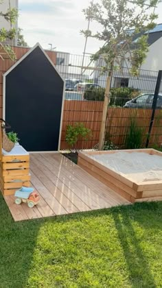 a wooden deck in the middle of a yard next to a fence and potted planter