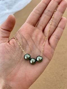 This necklace features three beautiful genuine Tahitian Pearls floating on a satellite chain. PLEASE NOTE: The genuine Tahitian Pearls will vary in shape, size and color and will have natural occurring birthmarks and or pits. They are as nature intended and part of the natural beauty of the pearls. The pearls will range and measure from 8mm to 10mm. These are stock photos, the necklace you receive will be similar but different. All White Sand Jewelry is handcrafted in Hawaii and comes in a hand Affordable 8mm Bead Pearl Necklace, Luxury Tahitian Pearl Pendant Jewelry, Cheap Adjustable Pearl Necklace For Beach, Luxury Tahitian Pearl Jewelry With Pearl Charm, Luxury Tahitian Pearl Round Beads Jewelry, Luxury Tahitian Pearl Necklace With Pearl Pendant, Luxury White Gold Tahitian Pearl Jewelry, Hawaiian Jewelry Necklace, Pearl And Gold Necklace