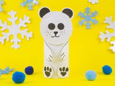 a paper cut out of a polar bear surrounded by snowflakes and blue balls