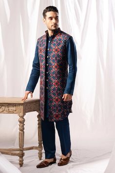 Navy blue long open bundi featuring patola pattern all over. Paired with a solid kurta and pant. - Aza Fashions Traditional Blue Nehru Jacket, Blue Kurta With Stand Collar, Traditional Blue Bandhgala With Stand Collar, Blue Long Sleeve Nehru Jacket For Festivals, Blue Traditional Wear For Winter, Traditional Blue Bandhgala For Winter, Traditional Blue Wear For Winter, Traditional Blue Outerwear For Festivals, Traditional Blue Sets For Winter