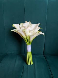 a bouquet of white flowers sitting on top of a green couch