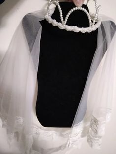 a mannequin wearing a white headpiece with pearls