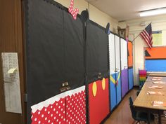 a classroom with many bulletin boards on the wall and desks in front of them