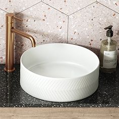 a white bowl sink sitting on top of a counter next to a faucet