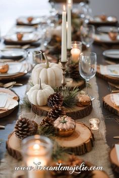 the table is set with pine cones, pumpkins and candles for an elegant thanksgiving dinner