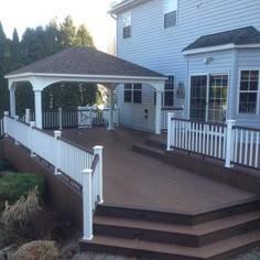 a white gazebo sitting on top of a wooden deck