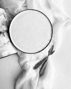 a white plate with scissors on top of it next to some napkins and flowers