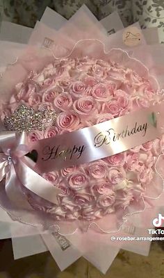 a bouquet of pink roses with a happy birthday ribbon on it's centerpiece