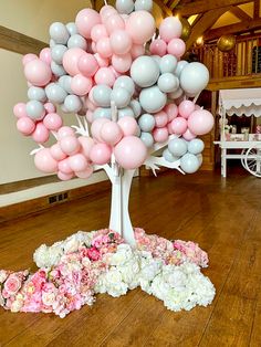 a bunch of balloons that are in the shape of a tree on a wooden floor