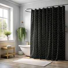 a white bath tub sitting under a window next to a shower curtain in a bathroom