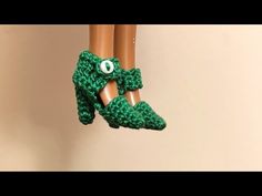 crocheted doll legs with green shoes and eyeballs hanging from the top of them