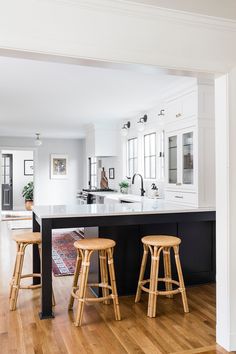 a kitchen with two stools and an island