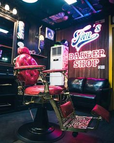 a barber chair in front of a neon sign