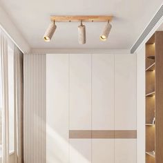 an empty room with some lights on the ceiling and shelves in front of it that also have bookshelves