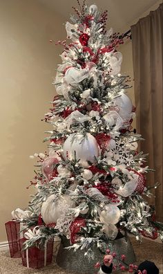 Flocked Christmas tree with large, medium, small ornaments. Red berries, bells, mesh ribbon. White snowflakes, beads, pine cones, ribbon. Red And Silver Flocked Christmas Tree, Red And Grey Christmas Tree, Red White And Silver Christmas Tree Decorating Ideas, Silver White Red Christmas Tree, Red White Silver Christmas Decor, White Silver And Red Christmas Tree, White Gold And Red Christmas Tree, Red And White Christmas Tree Ideas Holiday Decorating, Red White And Silver Christmas Decor