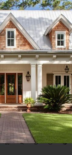 a house with white trim and brown shingles