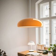 an office with a desk, chair and lamp in front of a window that looks out onto the street