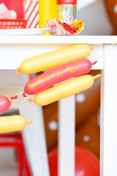 two hotdogs with ketchup and mustard on them hanging from a string