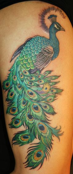 a woman's back with a peacock tattoo on it