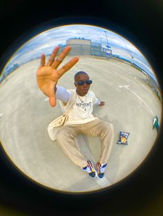 a man sitting on the ground with his hand up