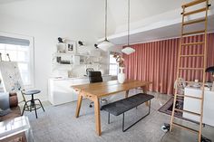 a living room filled with furniture and a wooden table in front of a red curtain