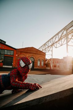 a person in a spiderman suit is laying on the ground