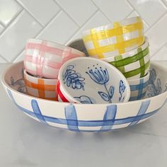 four colorful dishes in a bowl on a white counter top with tile backsplash