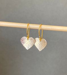 "Simple yet stylish handmade sterling silver and gold vermeil dangle earrings featuring a beautiful hand hammered heart. The heart is suspended from a french style 24k gold vermeil ear wire. Vermeil is a thick coat of 24 karat gold on solid sterling silver. The heart has been given a beautiful dimpled texture that catches the light. Lovingly designed and made by hand in the UK. Lightweight and comfortable to wear. They will add a lovely touch to any outfit and will make an ideal birthday or anni Thick Coat, 24 Karat Gold, Disc Earrings, Beautiful Gifts, Fun Earrings, Earrings Sterling Silver, Gorgeous Earrings, Handmade Sterling Silver, Jewelry Gift Box