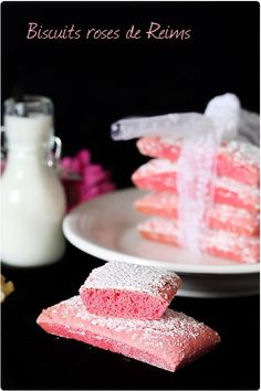 pink and white desserts on plates next to a bottle of milk with the words biscuits rose de rins