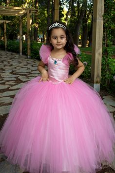 Here is our Rubies Pink Princess Dress, excellent for a Flower Girl! This fluffy court train rubies pink party gown is a great choice for toddler bridesmaid dress and junior wedding dress, as well as for pageants, birthdays, photo shootings and many other special occasions. It is made of dream tulle, crystal tulle, glitter printed crystal tulle, greek tulle and satin. It has a built-in petty coat for a fluffier look and embellished with bright rhinestone. The back of the tutu dress has lace-up s Princess Style Fitted Ball Gown For Dress-up, Pink Ball Gown Princess Dress For Debutante Ball, Pink Ball Gown For Debutante Ball, Pink Princess Dress With Fitted Bodice Ball Gown, Elegant Pink Princess Dress For Debutante Ball, Pink Tulle Pageant Dress With Fitted Bodice, Pink Princess Dress For Debutante Ball, Pink Pageant Dress With Fitted Bodice, Princess Style Ball Gown With Fitted Bodice