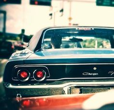 an old car is parked on the side of the road in front of a traffic light