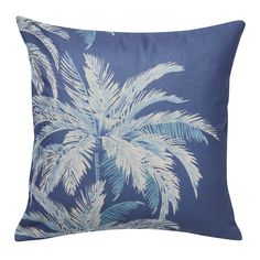 a blue pillow with white palm trees on it