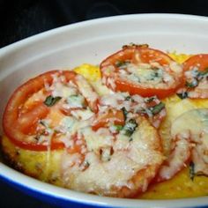 some food is in a white bowl on a black tablecloth and there are tomatoes