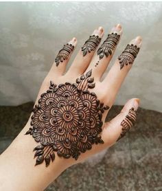 the hand is decorated with henna designs on it's fingers and palm area