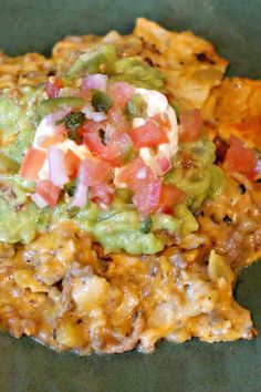 nachos are topped with guacamole and tomatoes