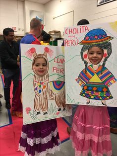 two children are holding up their art work