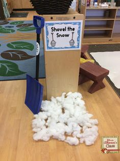 a shovel and some cotton balls on a table in front of a sign that says shovel the snow