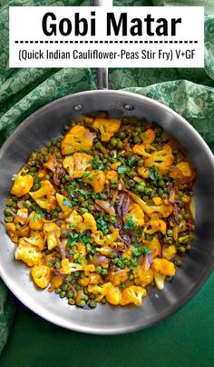 gobi mata with peas and carrots in a pan on a green table cloth