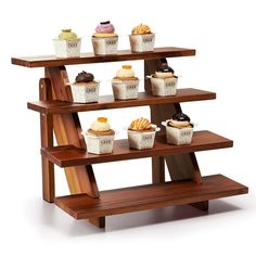 three tiered wooden display case with cupcakes and other pastries on it