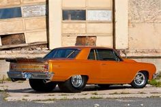 an orange car parked in front of a building