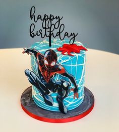 a birthday cake with a spiderman figure on it's side and the words happy birthday written in black