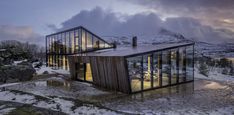 two glass houses sit on top of a snowy hill