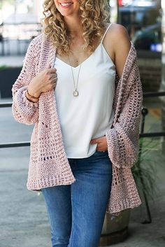 a woman wearing a pink cardigan with text overlay that reads hexagon cardigan free crochet pattern + video